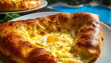 Golden-baked Easy Khachapuri with a runny egg center served on a white plate near a poolside, showcasing its crisp crust and melted cheese.