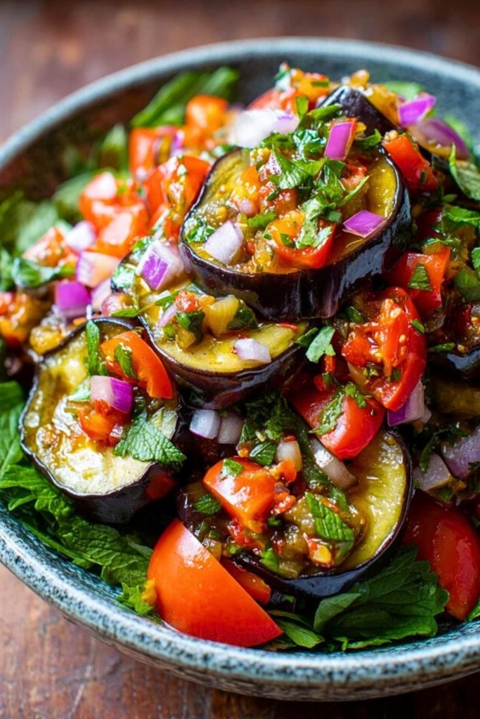 Rustic-style Eggplant Salad with vibrant grilled eggplant, chopped tomatoes, red onions, and herbs in a ceramic bowl on a wooden table.