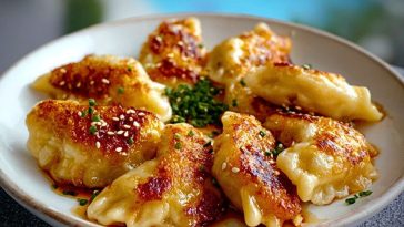 Golden crisp Potato Pierogi arranged in a circle on a white plate, sprinkled with sesame seeds and chives, with a poolside view in the background.