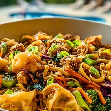 Potsticker Noodle Bowls served in a white bowl with vibrant veggies, sesame seeds, and dumplings under golden sunlight.