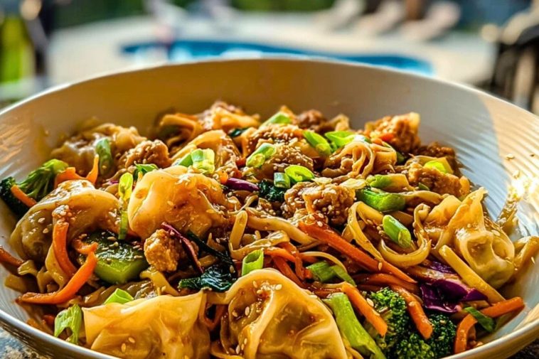 Potsticker Noodle Bowls served in a white bowl with vibrant veggies, sesame seeds, and dumplings under golden sunlight.