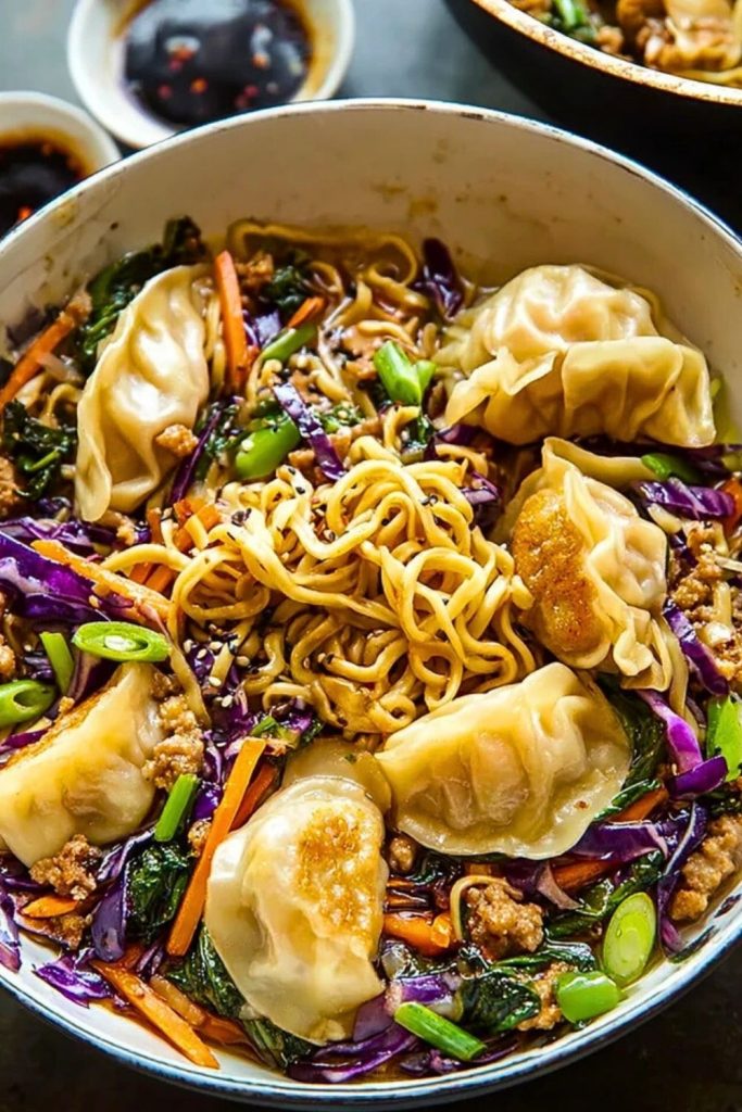 Overhead view of Potsticker Noodle Bowls with ramen, colorful vegetables, and golden pan-seared dumplings in a white dish.